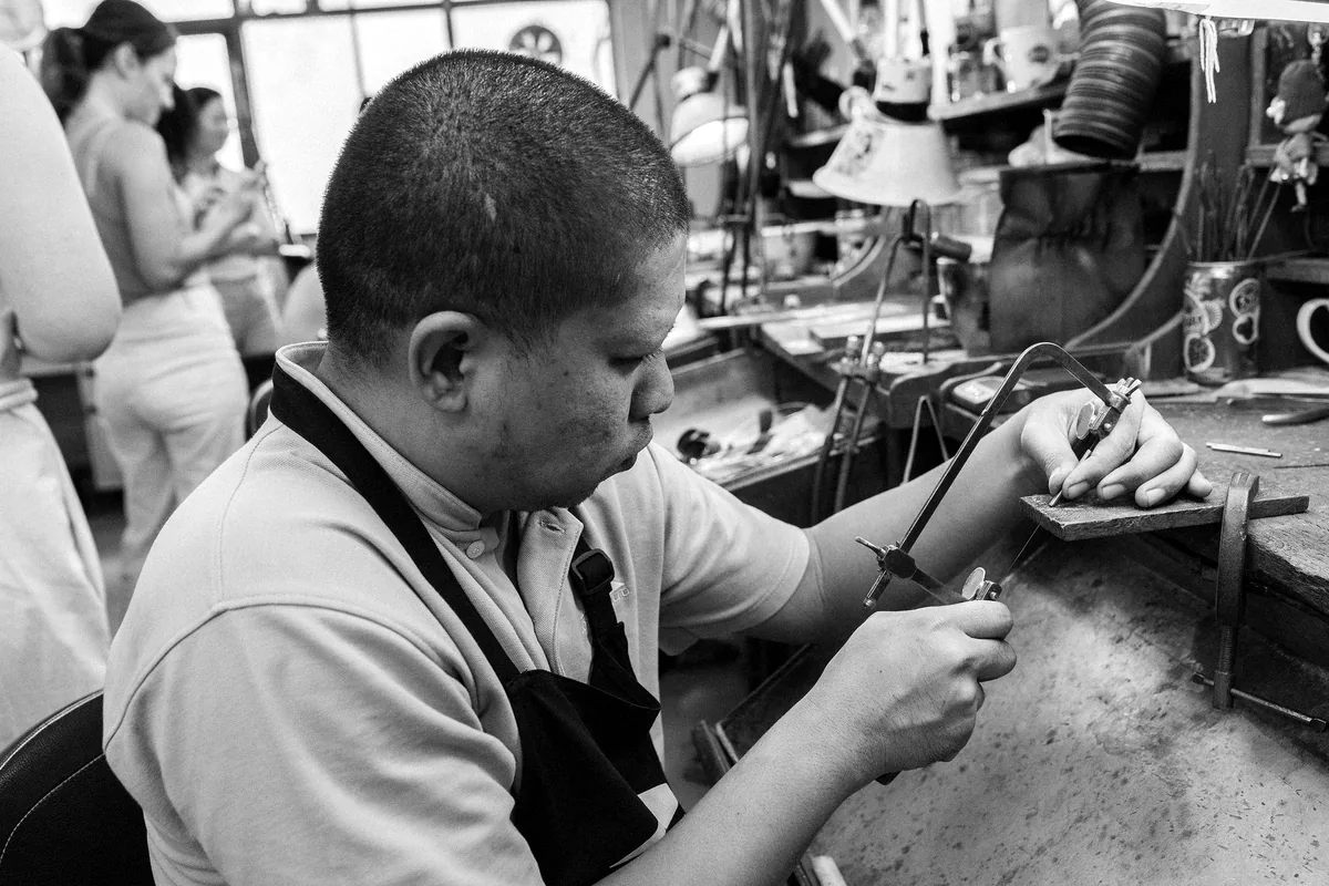 Người thợ ngồi chế tác trang sức tại bàn